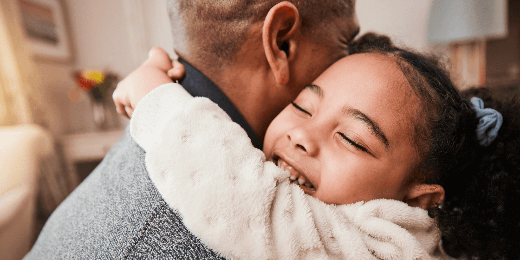 Young girl hugging a father figure.